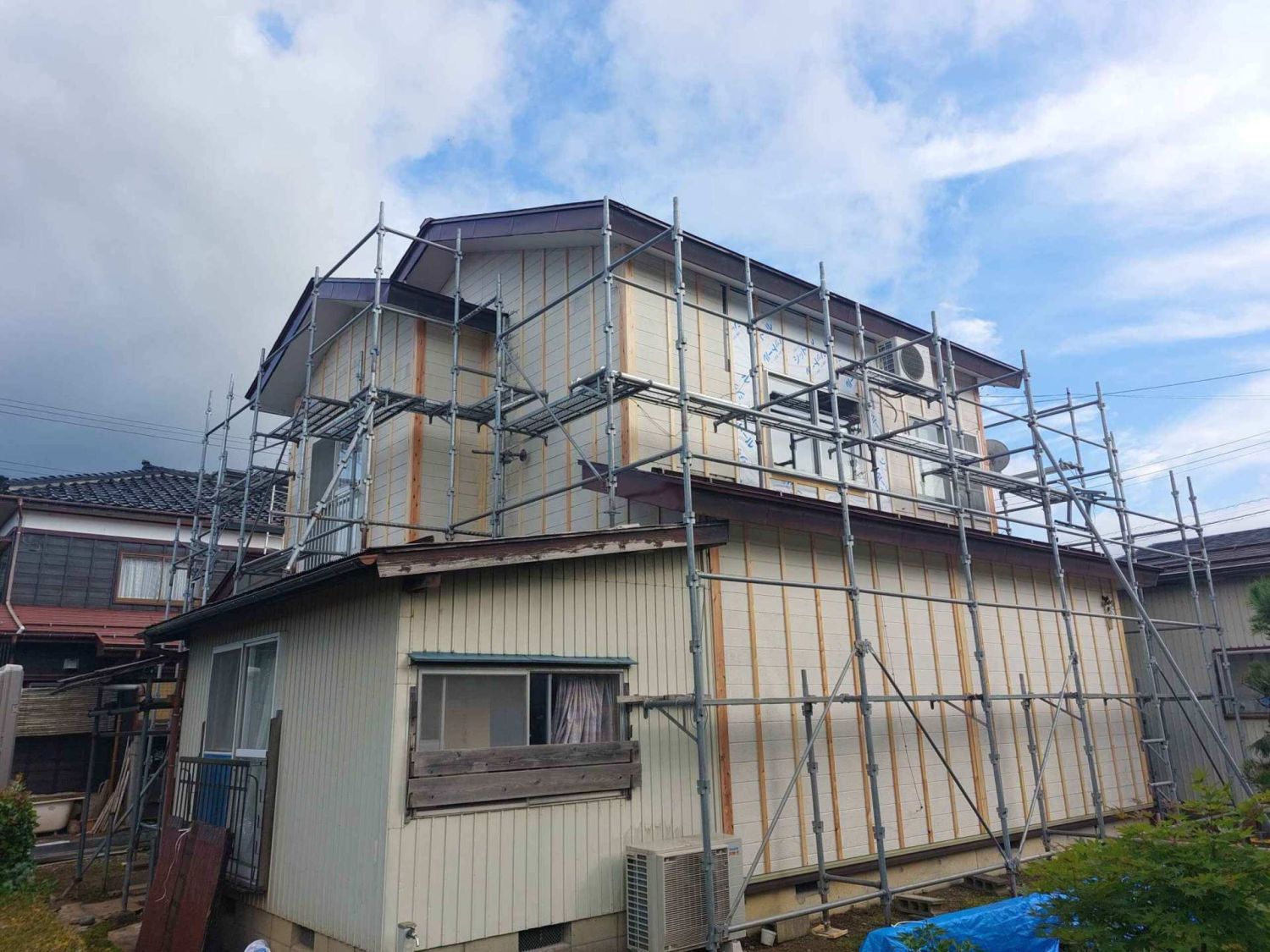 足場を組んで行う住宅の外壁塗装工事の様子